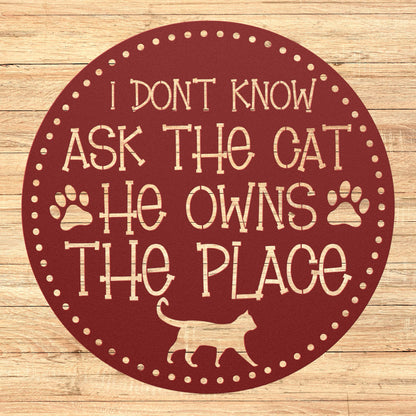 Circular Metal Sign that reads "I Don't know Ask the Cat, He Owns the Place"